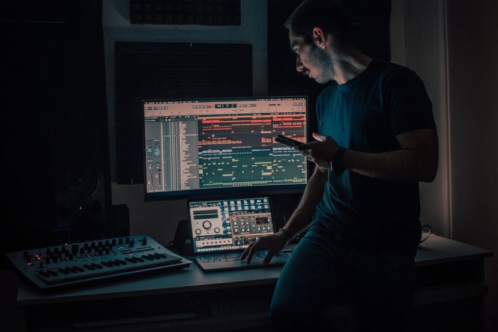 Young music producer in home studio at night