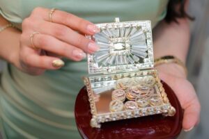 Woman holding ornate jewelry box filled with coins